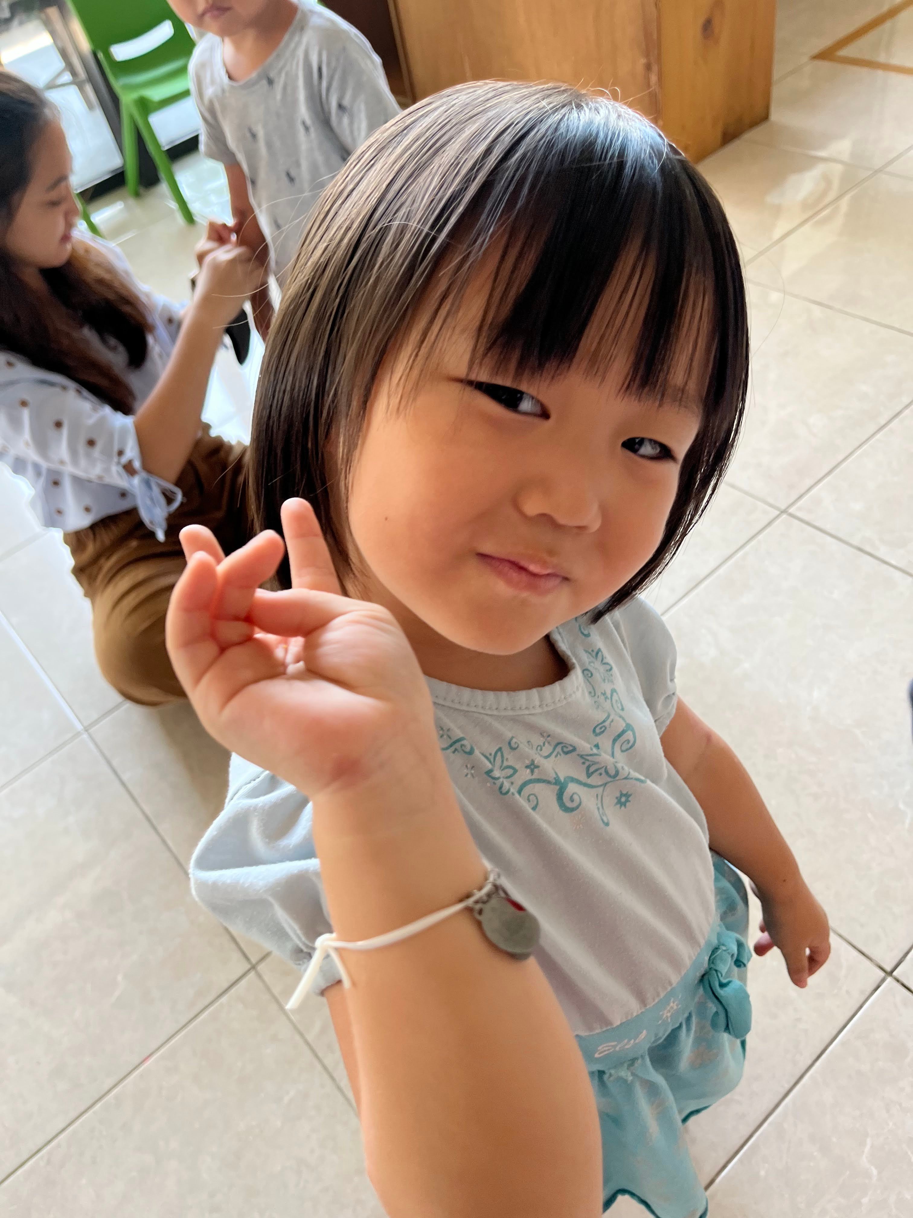 little indonesian girl showing off her gospel bracelet to the camera