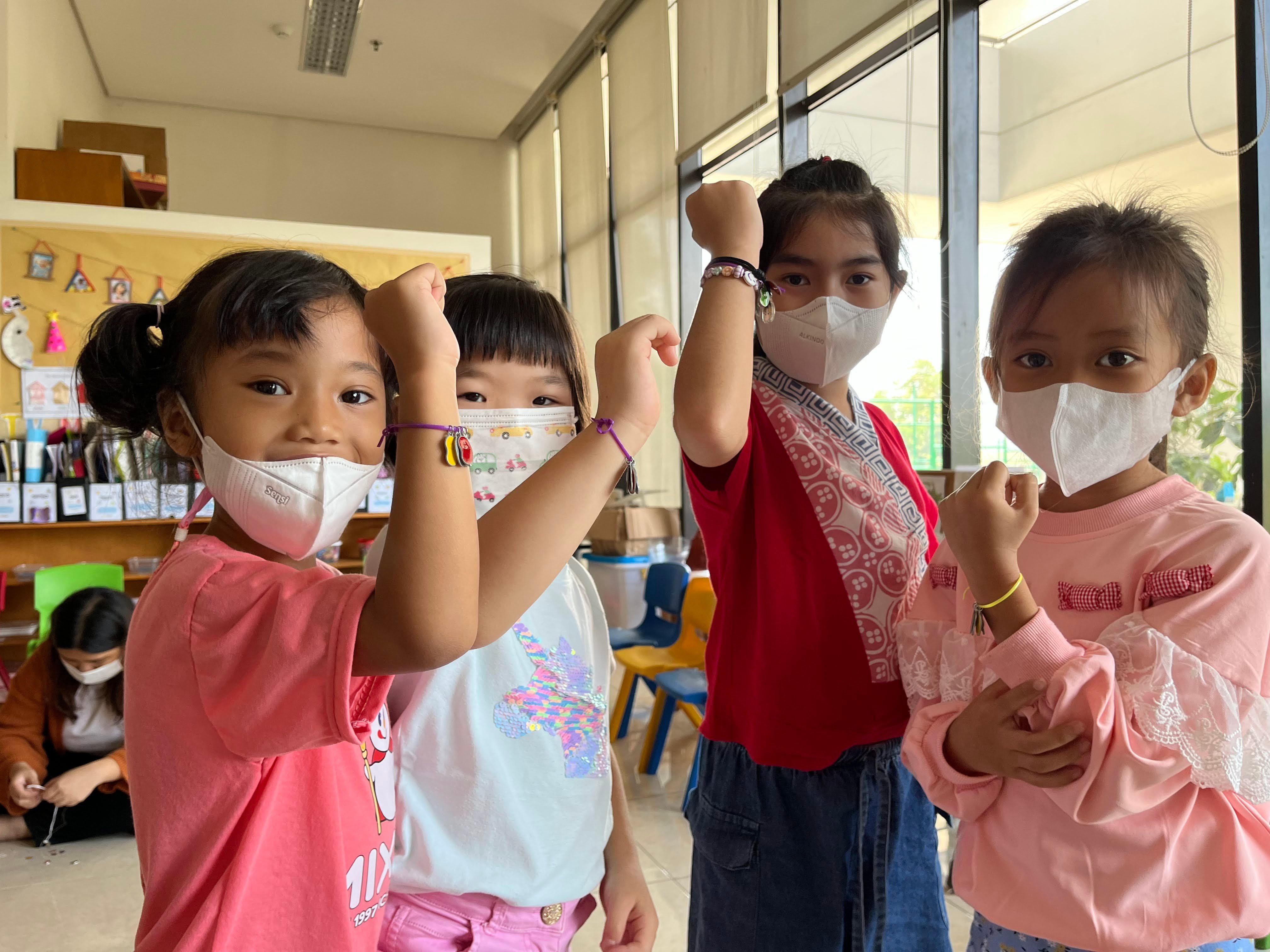 4 indonesian kids holding up bracelets made sharing the gospel story