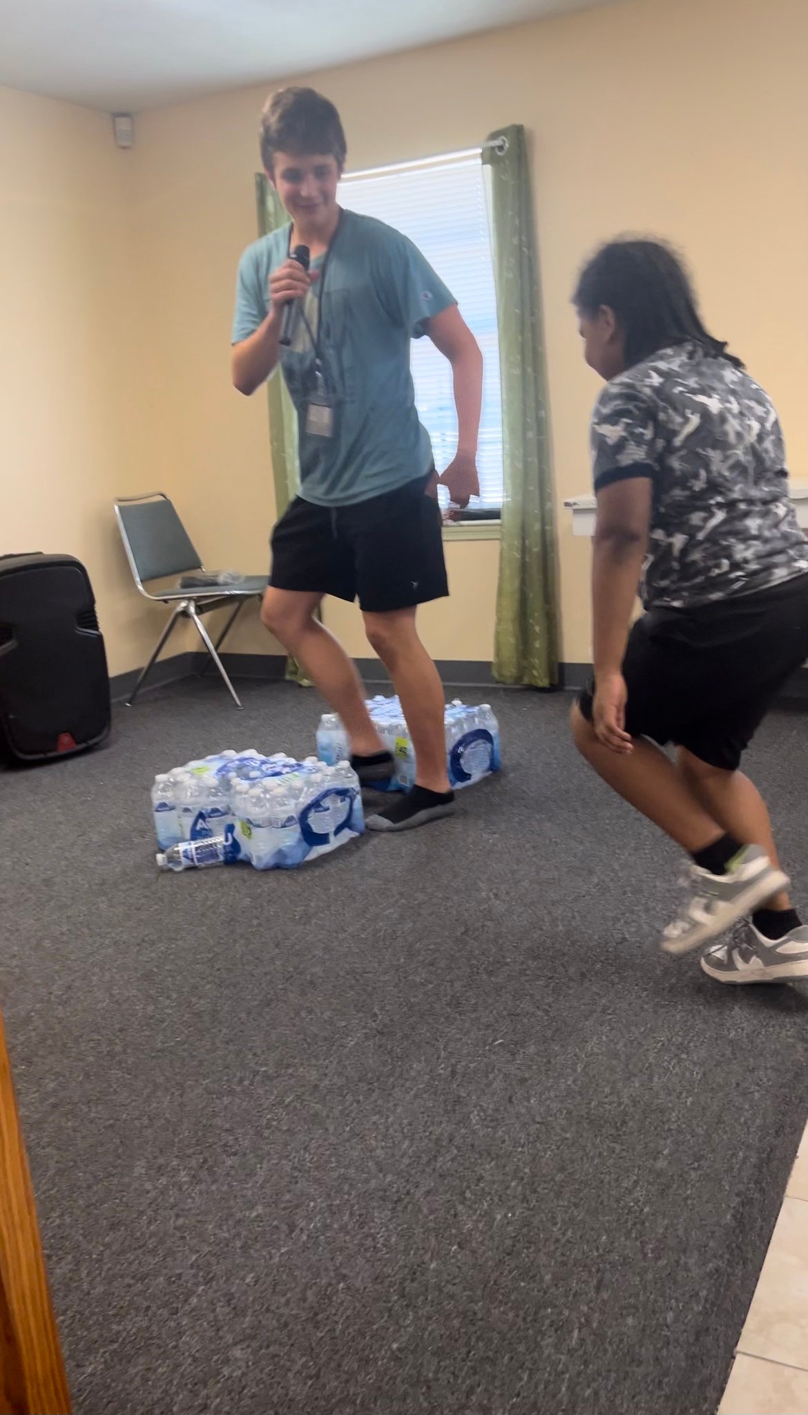 two kids walking through cases of water 