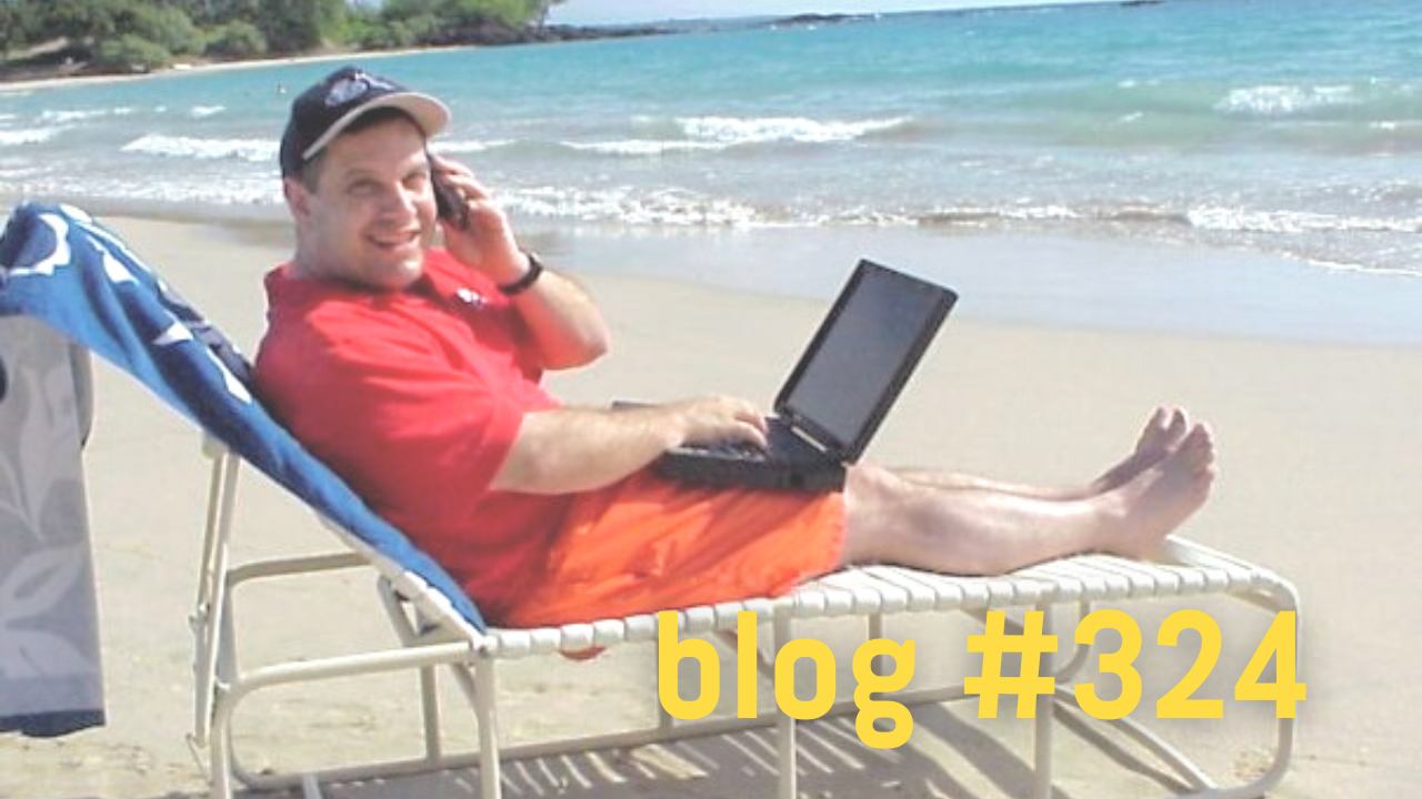 man on the beach with phone and computer